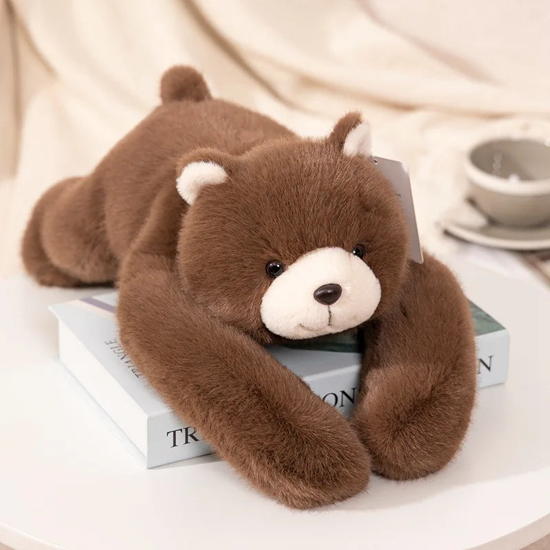 Peluche ours brun lestée allongée sur une pile de livres