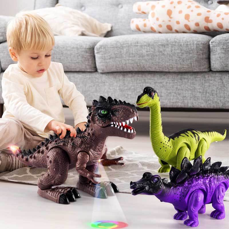 Tout-petit sur un tapis avec trois dinosaures marcheurs projetant des lumières au sol