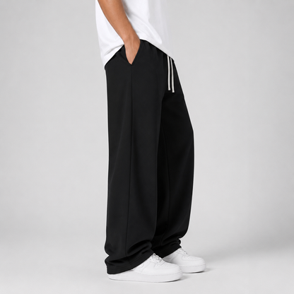 Pantalon jogging homme noir porté de profil, main dans la poche latérale