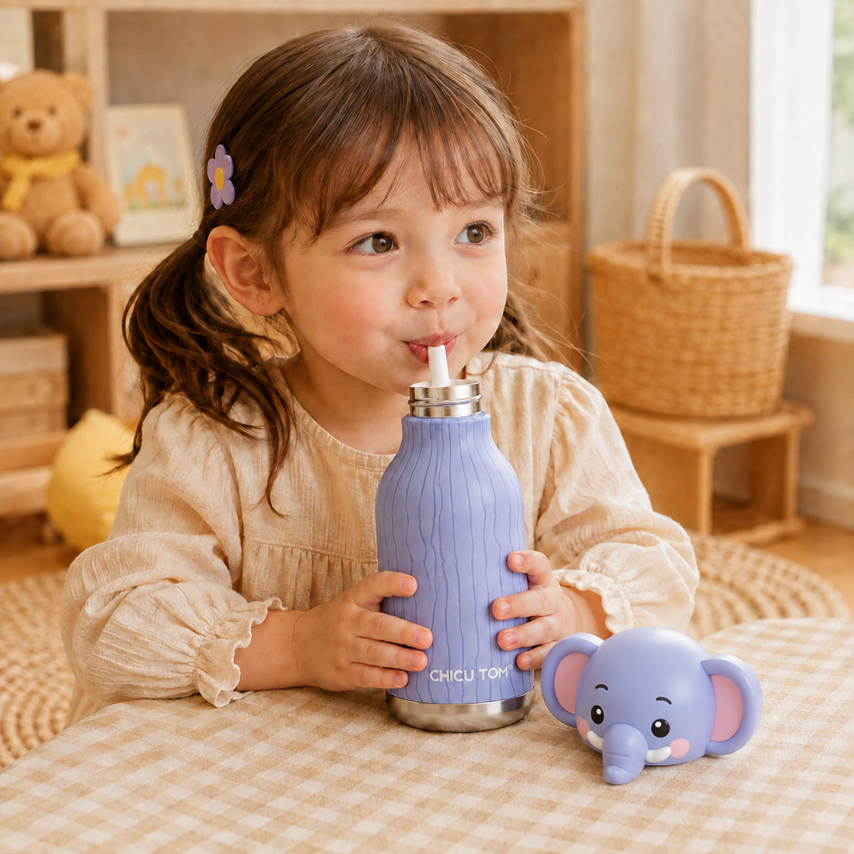 Petite fille buvant à la paille intégrée de la gourde violette design éléphant