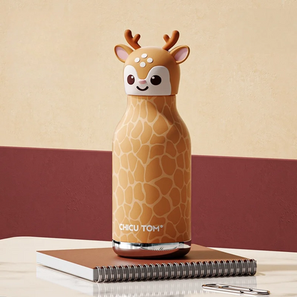 Gourde design biche avec housse à motif girafe posée sur un cahier