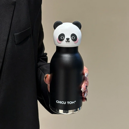 Gourde panda noir mat tenue en main contre un blazer noir