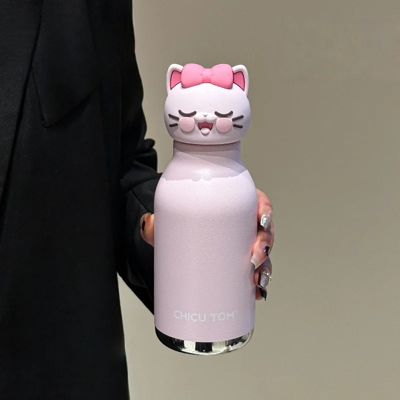 Gourde chat rose avec détail nœud tenue en main contre un blazer noir