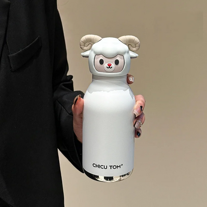Gourde chevreau blanche aux cornes recourbées tenue en main contre un blazer noir
