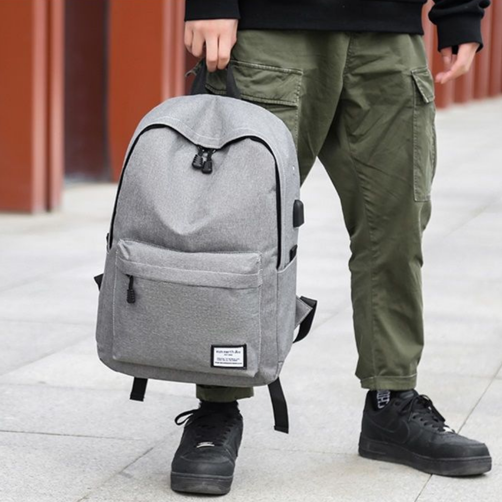 Personne tenant le sac à dos ordinateur gris avec port USB en extérieur