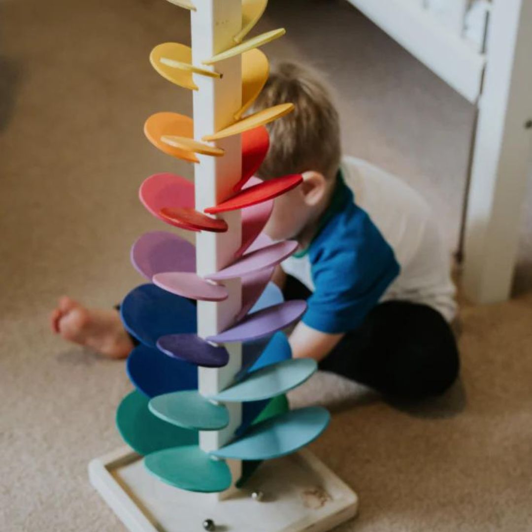 Enfant jouant avec la tour sonore arc-en-ciel en bois