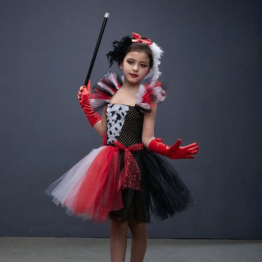 Fillette portant un costume à taches noir et blanc avec headband à plumes, gants rouges et canne décorative