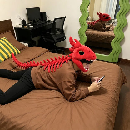 Personne allongée portant la coiffe peluche squelette de dinosaure rouge