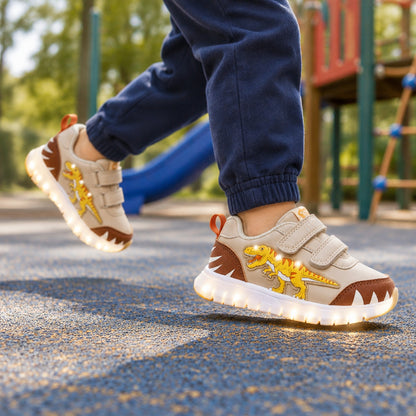 Enfant portant les baskets LED dinosaure beiges en extérieur