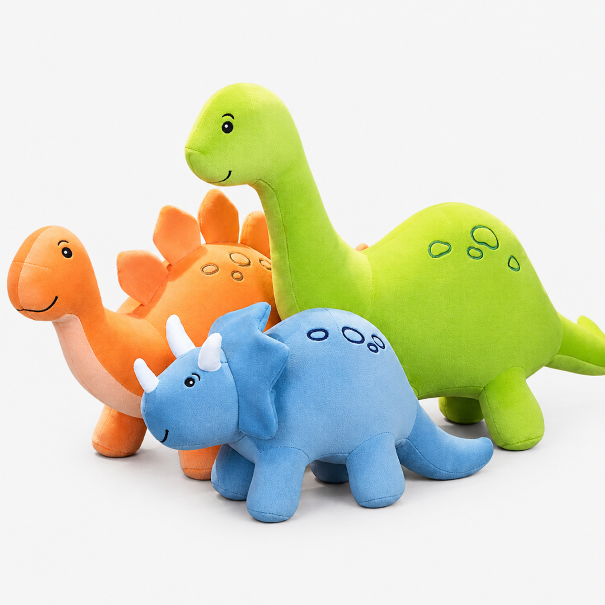 Trois peluches dinosaure, vert, orange et bleu, 30 cm, alignées ensemble