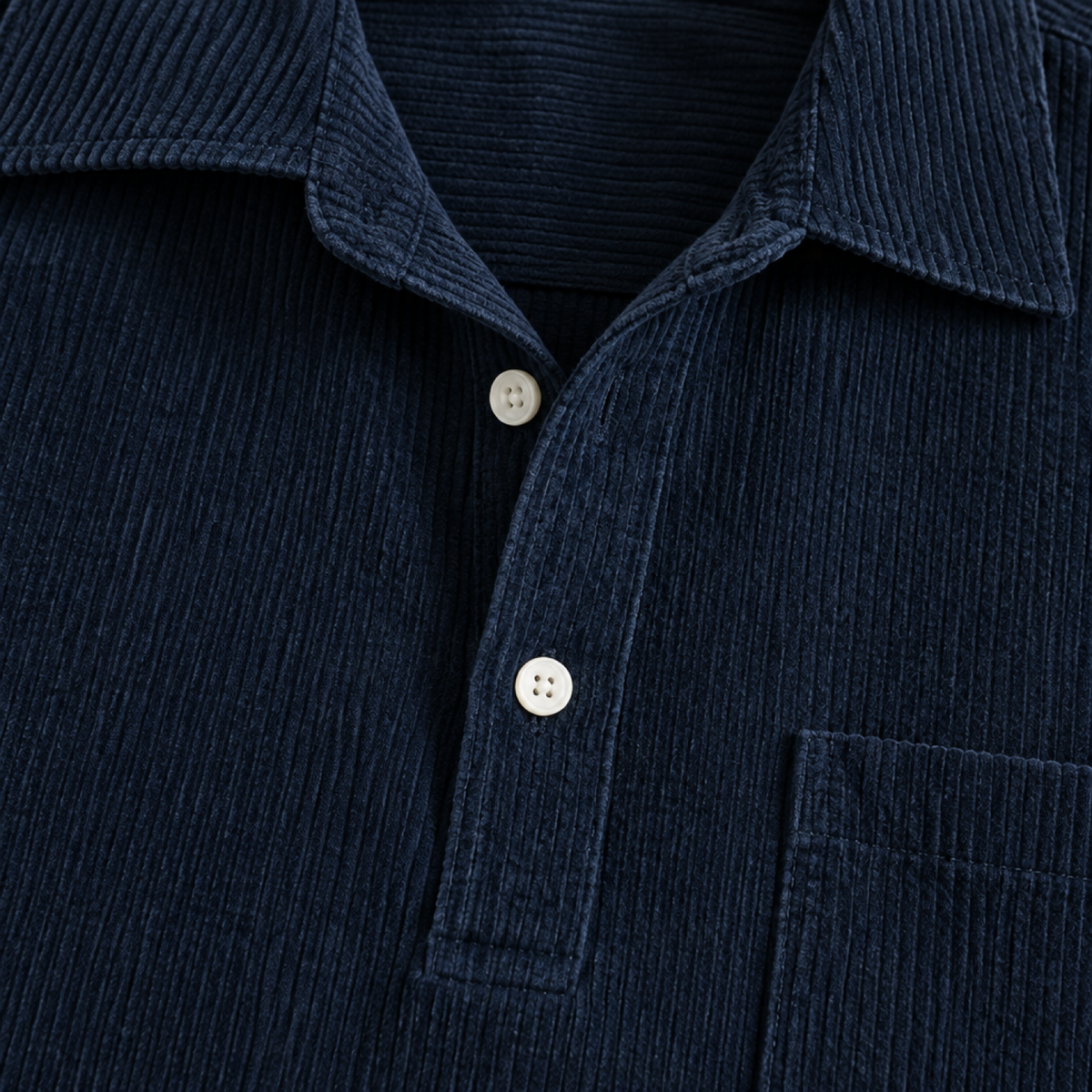Gros plan sur la texture côtelée du velours et les boutons de la chemise bleu marine