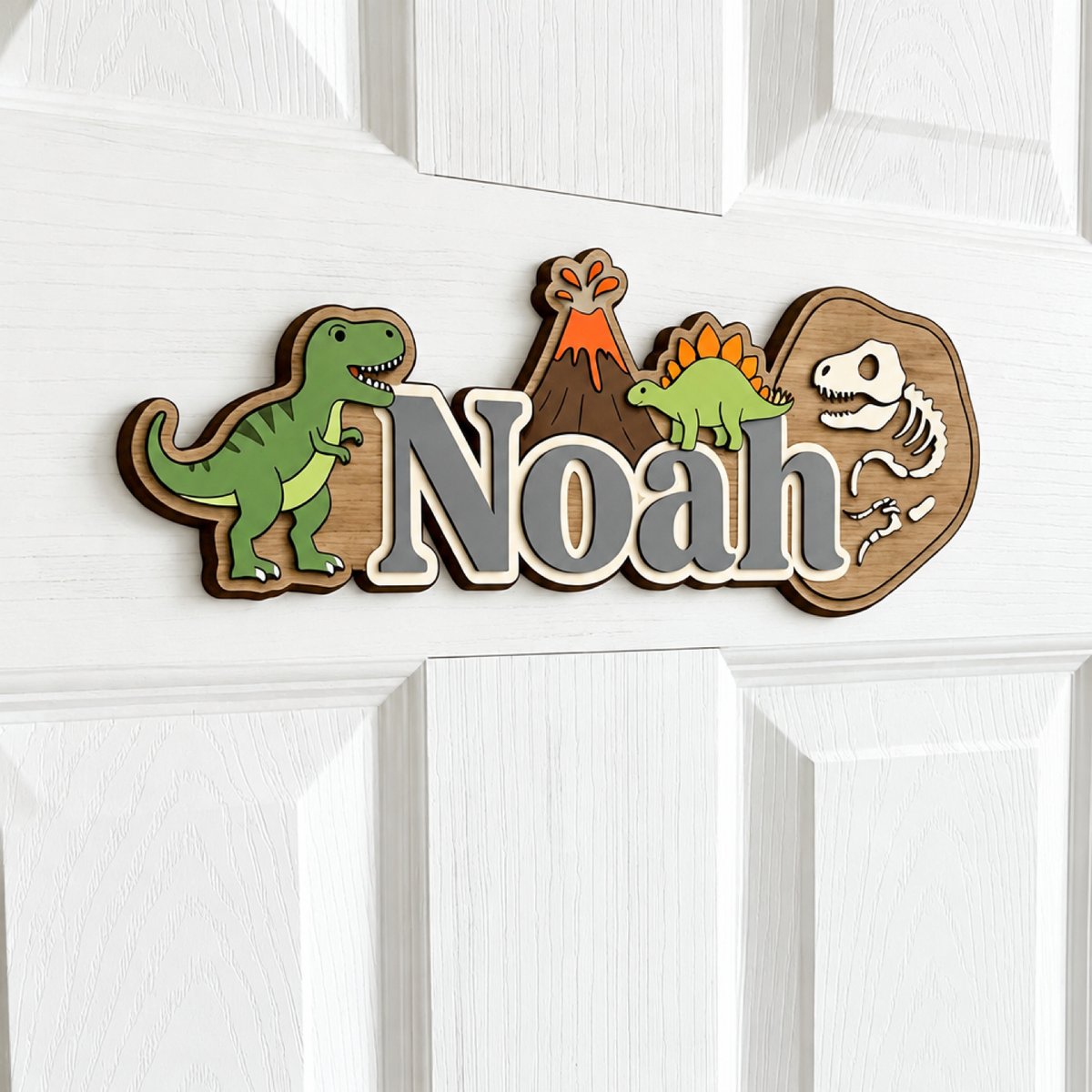 Vue de côté de la plaque prénom dinosaure en bois avec lettrage gris montrant la construction 3D en couches