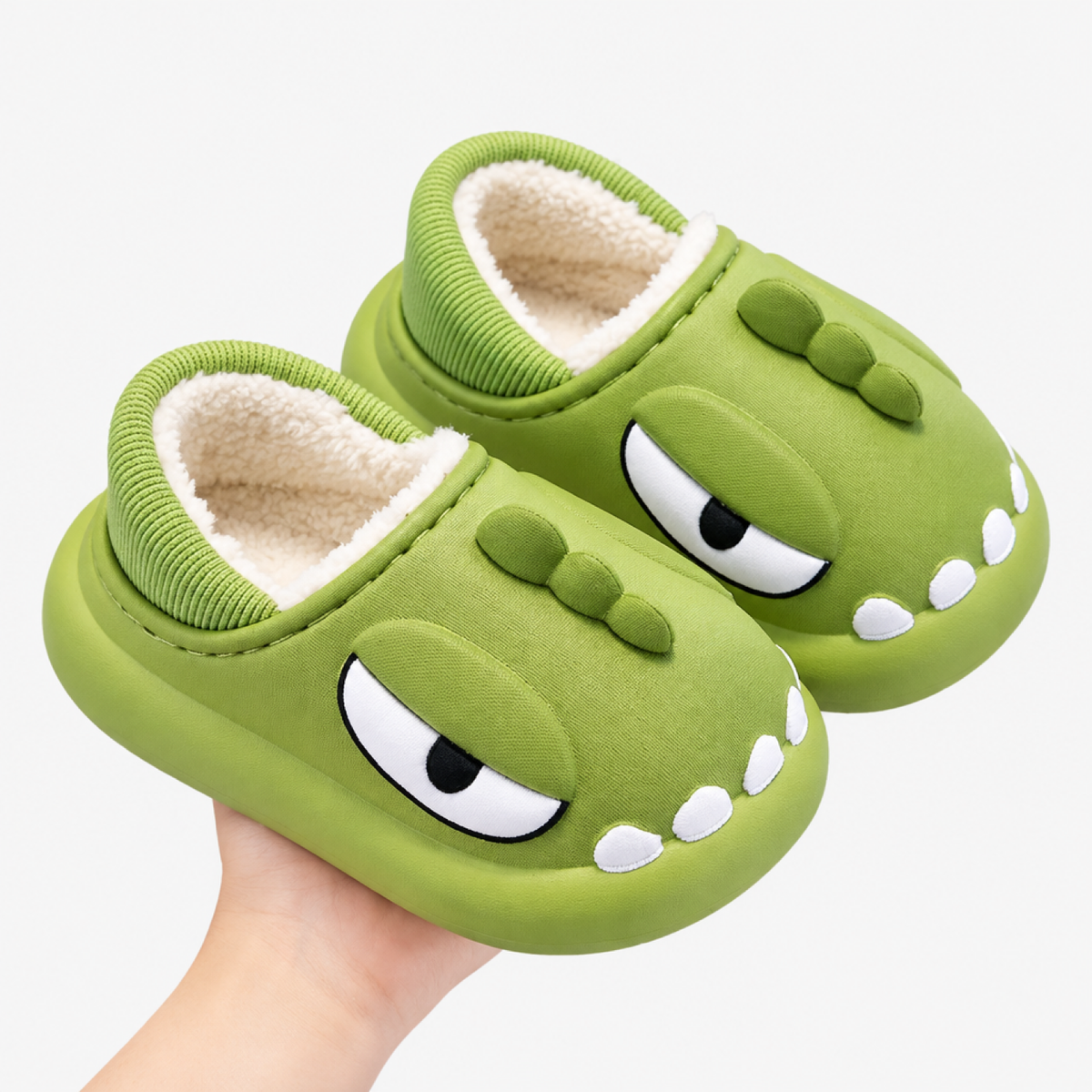Paire de chaussons dinosaure vert foncé en coton, fond studio blanc