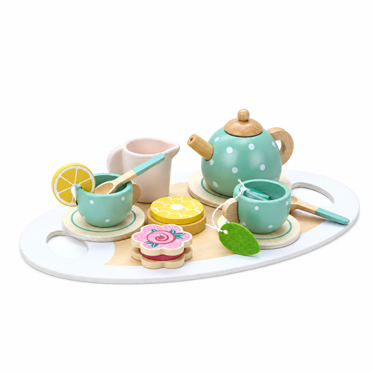 Gros plan de la dînette en bois avec biscuit, part de gâteau et tranche de citron factices à côté de la théière et des tasses
