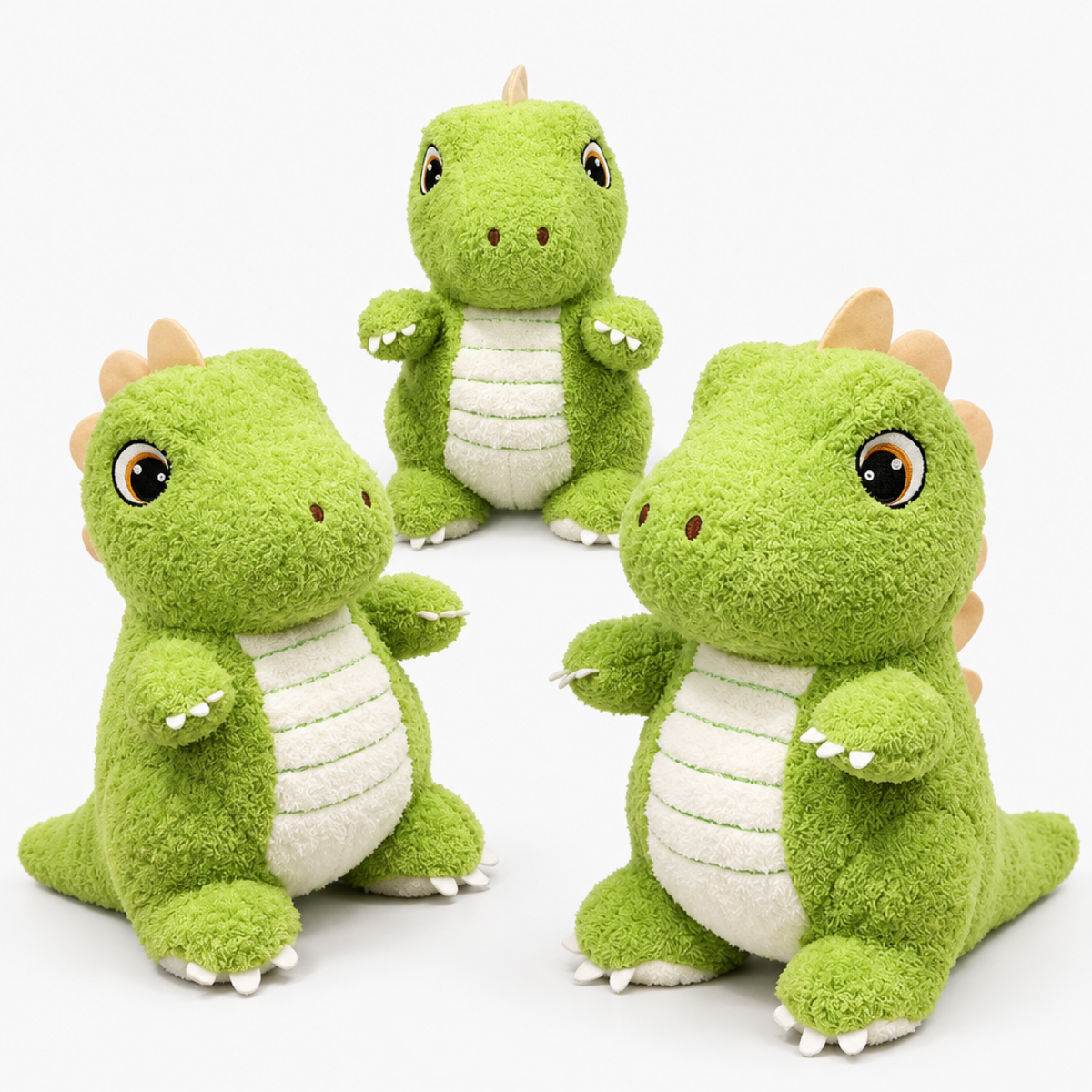 Trois peluches dinosaure vertes côte à côte en 25 cm, 35 cm et 45 cm, photo studio fond blanc