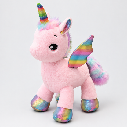 Peluche licorne rose, photo studio vue de trois quarts avant montrant la crinière arc-en-ciel, la corne, les ailes et les sabots