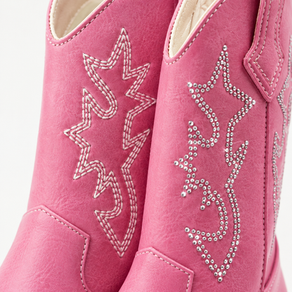 Gros plan sur les points de broderie et les strass des bottes de cowboy western pour enfant