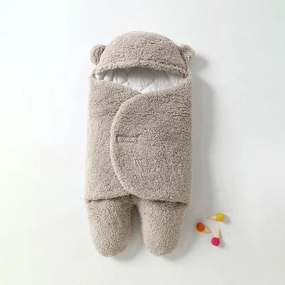 Nouveau-né emmitouflé dans la gigoteuse peluche à capuche