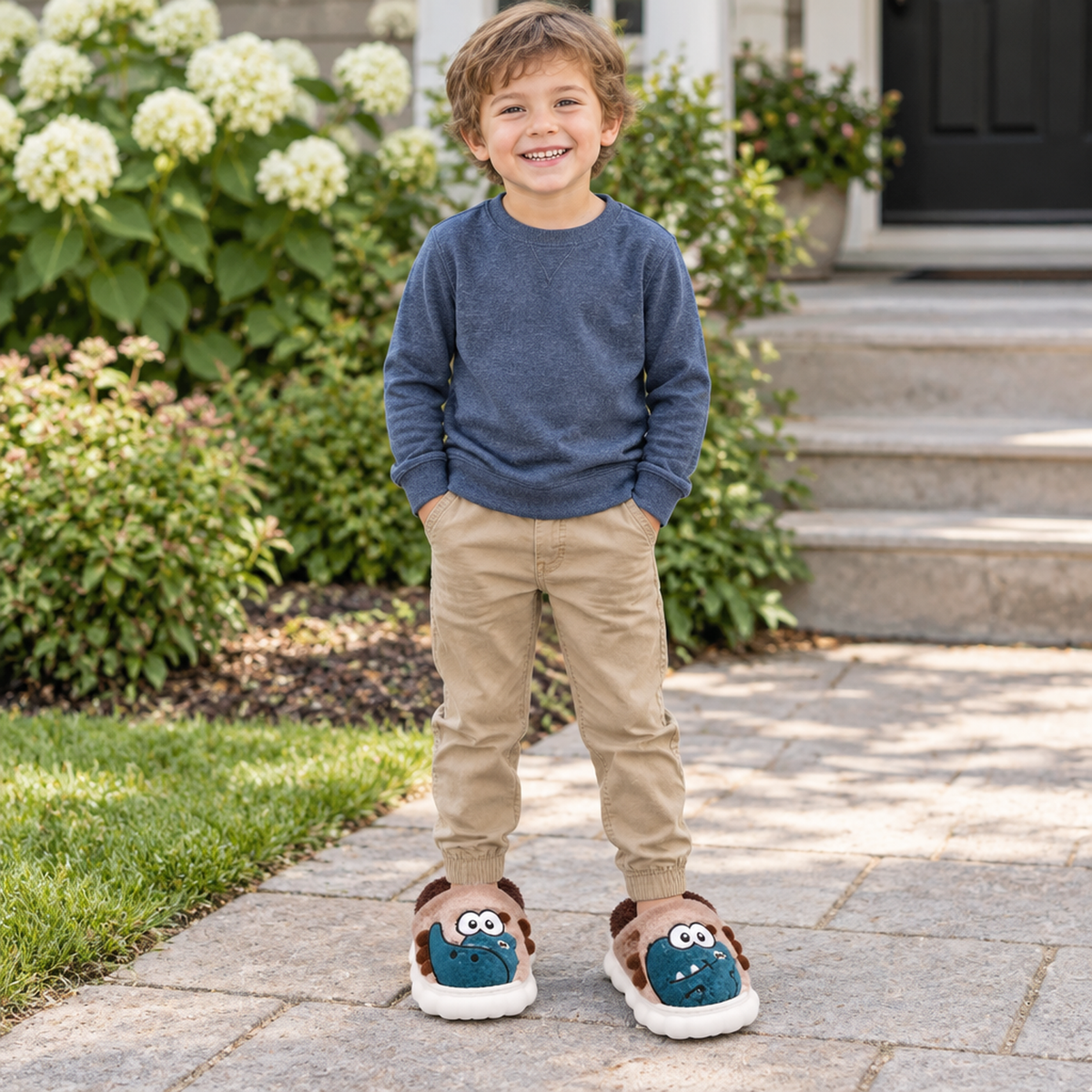 Enfant portant les chaussons monstre gris à l'extérieur, allée en pierre