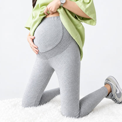 Femme enceinte portant le legging maternité thermique doublé velours gris clair avec soutien ventre