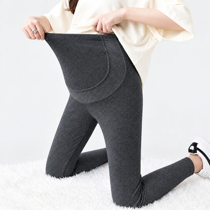 Femme enceinte portant le legging maternité thermique doublé velours gris foncé avec bande ventre haute