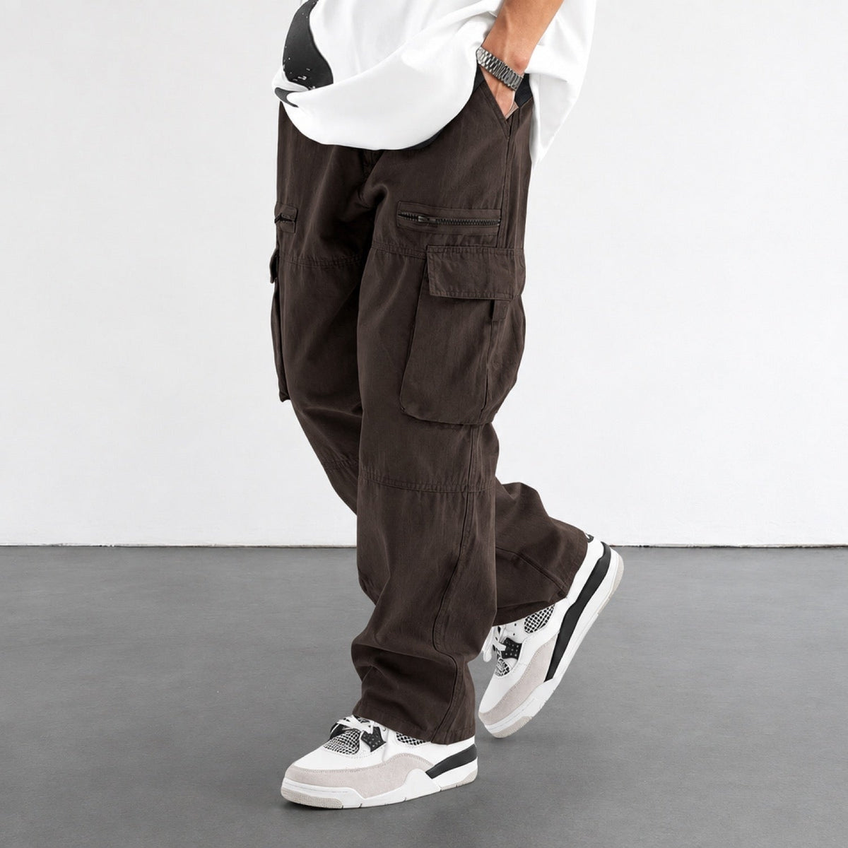 Pantalon cargo homme marron, coupe large, vue de profil avec poches à rabat et poche zippée