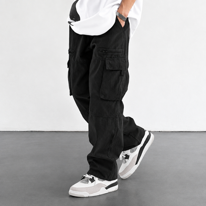 Pantalon cargo homme noir, coupe large, vue de profil avec poches cargo à rabat