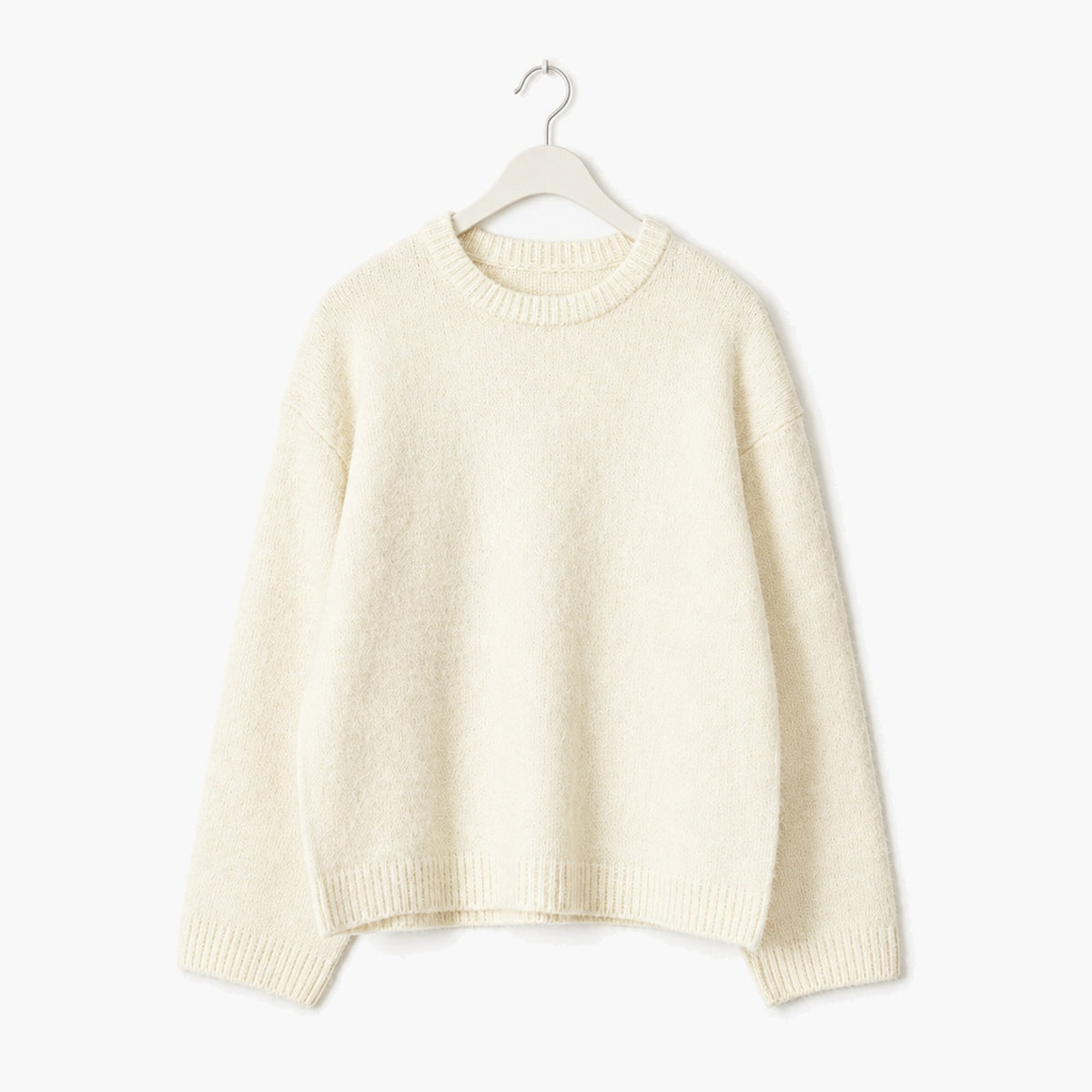 Pull oversize femme crème en maille douce et moelleuse, col rond – présenté sur cintre