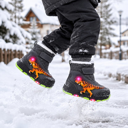 Enfant sautant dans la neige avec les bottes de neige lumineuses grises motif dinosaure, semelle LED allumée