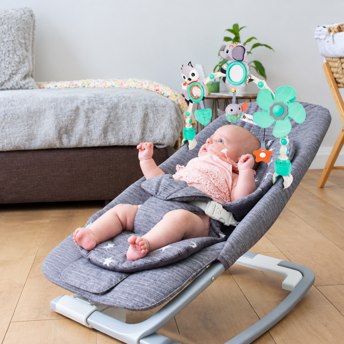 Bébé allongé dans un transat avec la barre de jeu musicale fixée au-dessus